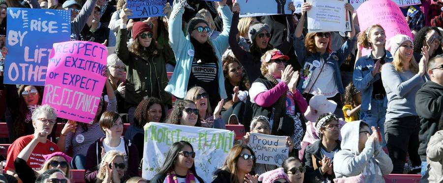 Attendees hold signs during the Women's March 'Power to the Polls' voter registration tour launch at Sam Boyd Stadium on January 21, 2018 in Las Vegas, Nevada.