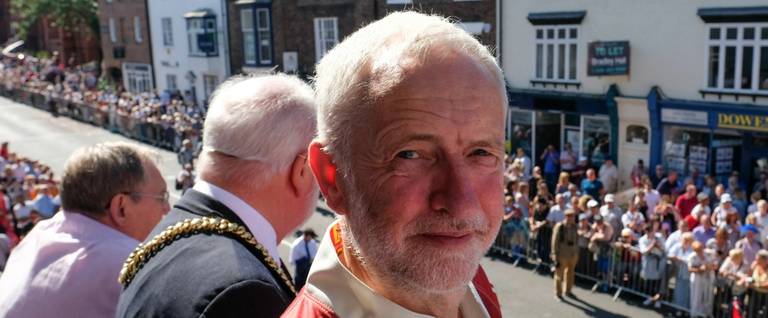 Labour leader Jeremy Corbyn stands on the balcony of the County Hotel watching as colliery bands pass below during the 134th Durham Miners’ Gala on July 14, 2018 in Durham, England.