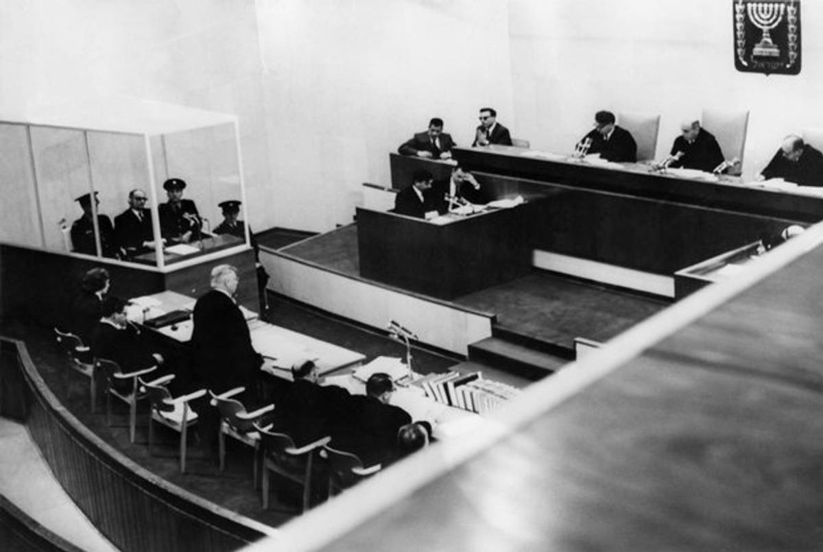 Adolf Eichmann sits in his bullet-proof dock as Tribunal judges (R to L) Itzhak Raveh, Moshe Landau, President and Bejamin Halevi start the opening session of the tribunal assembled to try former Nazi SS leader, Jerusalem 11 April 1961. (AFP/Getty Images)