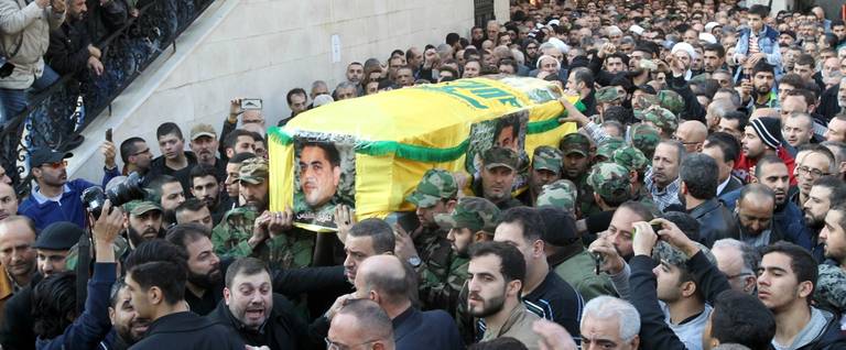 Members of Lebanon's militant Shiite Muslim movement Hezbollah carry the coffin of Lebanese militant Samir Kantar (portrait), who was killed in a suspected Israeli air-raid on his home in the Jaramana district on the outskirts of the Syrian capital Damascus, during his funeral procession in a southern suburb of Beirut, Lenabon, December 21, 2015. 