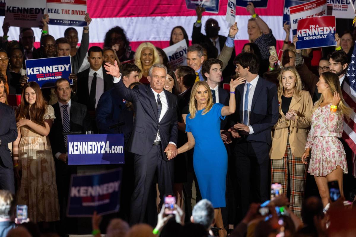 Robert F. Kennedy Jr. and his wife, actress Cheryl Hines, wave to supporters on stage after announcing his candidacy for president in Boston on April 19, 2023
