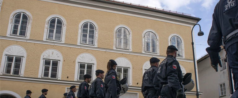 Austrian police officers walk by the house where Adolf Hitler was born during the anti-Nazi protest in Braunau Am Inn, Austria, April 18, 2015.
