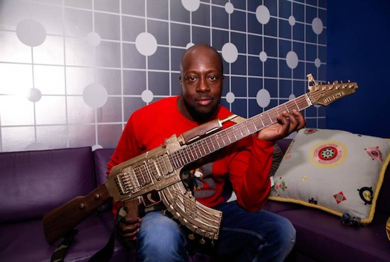 Wyclef Jen poses backstage with a guitar shaped like a AK-47 before taping a segment on BET's 106 & Park on May 1, 2013 in New York City.(Getty)