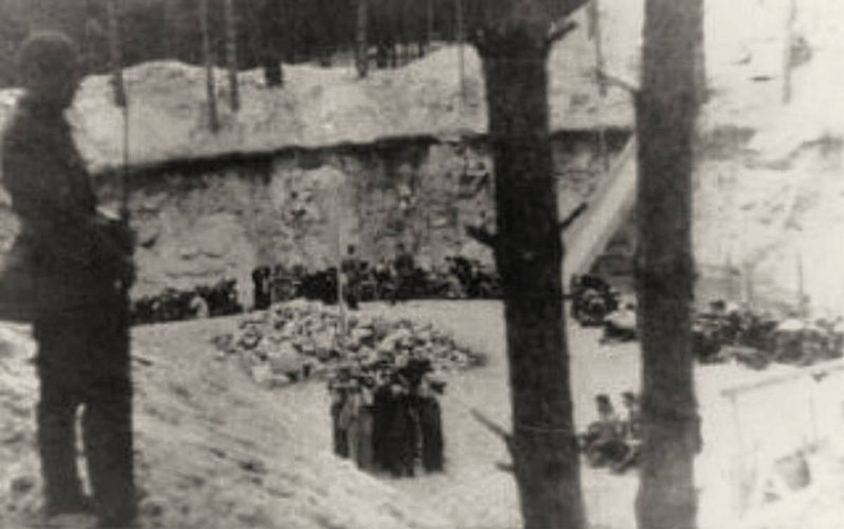 An image of the Ponary executions, July 1941. A ramp leads from the ground level, visible between tree trunks. Below, Polish Jews of the Vilna Ghetto. (Wikimedia)