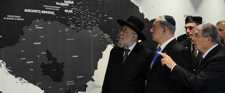 Yad Vashem Chairman Avner Shalev (R) flanked by Israeli Prime Minister Benjamin Netanyahu and Rabbi Yisrael Meir Lau (L) at the opening of the Permanent Exhibition SHOAH at former Nazi death camp in the Auschwitz-Birkenau State Museum, Block 27, in Oświęcim, Poland, June 13, 2013.