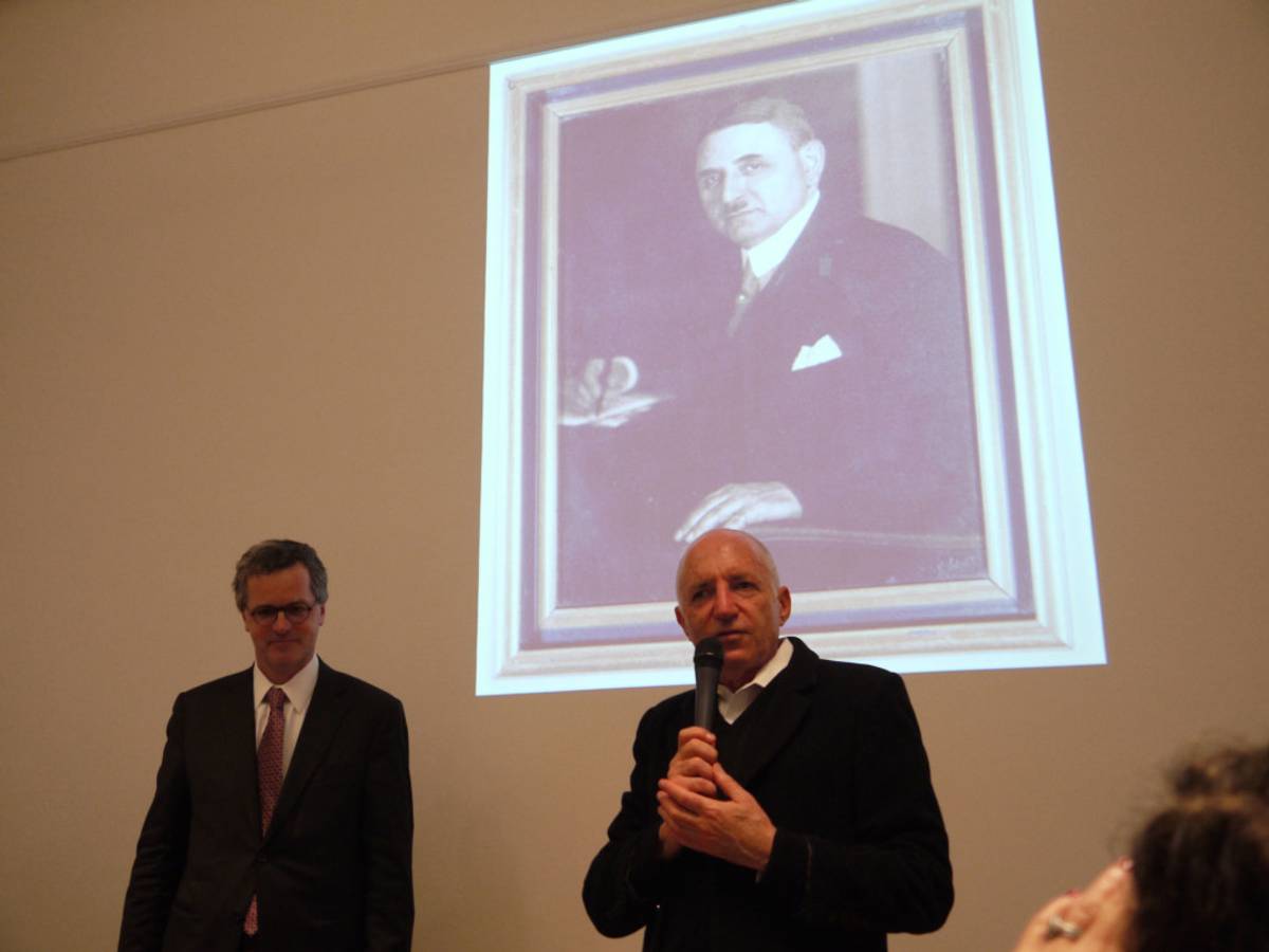 Michael Hayden speaking at Merkelstrasse 3, beneath a photo of his grandfather. (Photo: Hayden Family)