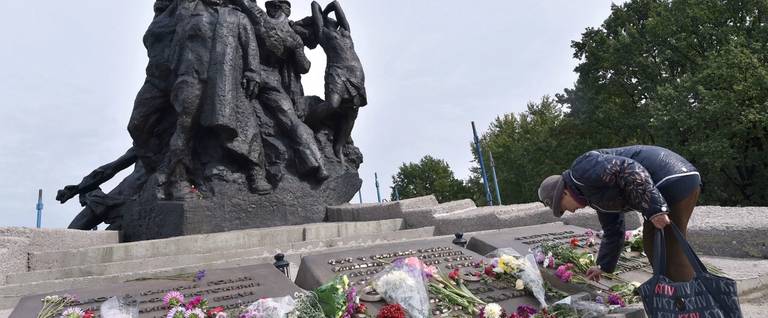Ukraine's Raisa Maistrenko, who was 3 years old at the time of the massacre at Babi Yar, lays flowers during a visit to the memorial monument in Kyiv, Sept. 23, 2016 
