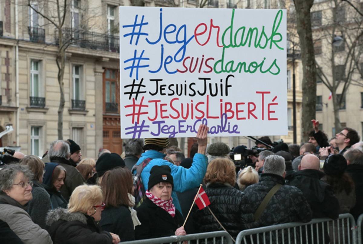 A man holds a placard with the hashtags 'I am Danish, I am Jewish, I am Freedom' next to a woman holding a Danish flag outside the Danish Embassy in Paris on February 16, 2015. (JACQUES DEMARTHON/AFP/Getty Images)