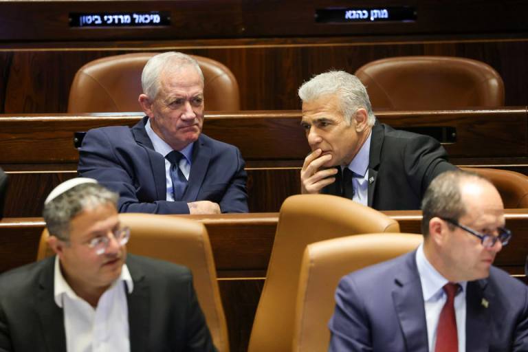 Yair Lapid (rear right) and Benny Gantz (rear left) attend a voting session in the Knesset on March 27, 2023