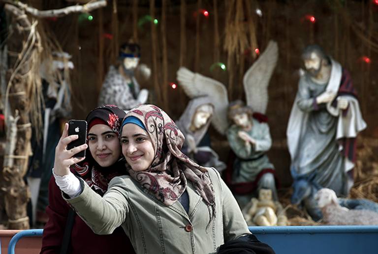 Women take a selfie in front of in front of the Church of the Nativity. (THOMAS COEX/AFP/Getty Images)