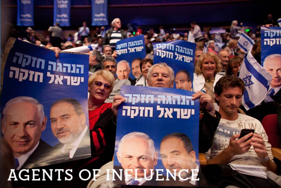 Israelis hold posters of Prime Minister Benjamin Netanyahu and former Foreign Minister Avigdor Lieberman during the launch of the Likud-Beitenu election campaign on December 25, 2012, in Jerusalem.(Uriel Sinai/Getty Images)