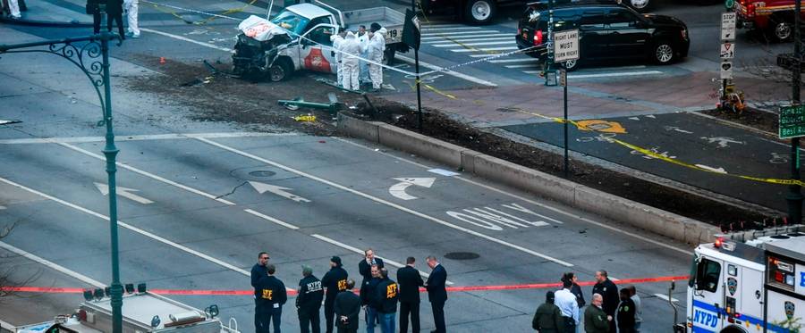 Investigators inspect a truck following a shooting incident in New York on October 31, 2017. Several people were killed and numerous others injured in New York on Tuesday when a suspect plowed a vehicle into a bike and pedestrian path in Lower Manhattan, and struck another vehicle on Halloween, police said.