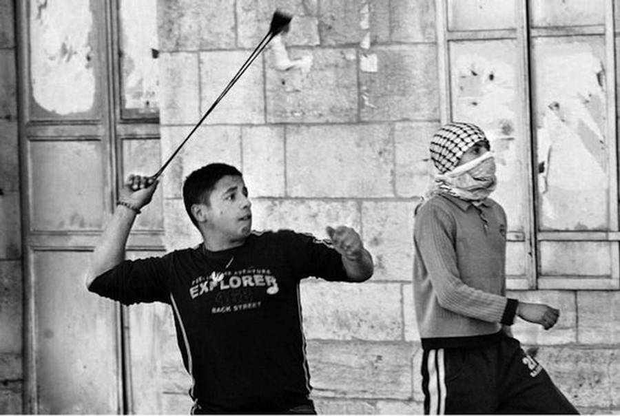 A Palestinian hurls a stone towards an Israeli armywatch-tower during clashes in Bethlehem in March 2007(HinduTimes)