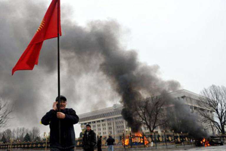 A Kyrgyz opposition supporter waves the national flag near the main government building during an anti-government protest in Bishkek on April 7, 2010.(Vyacheslav Oseledko/AFP/Getty Images)