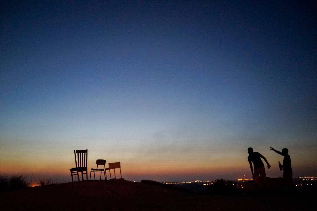 Locals watch the bombing of Gaza from a hill in the town of Sderot, overlooking Gaza, 2014