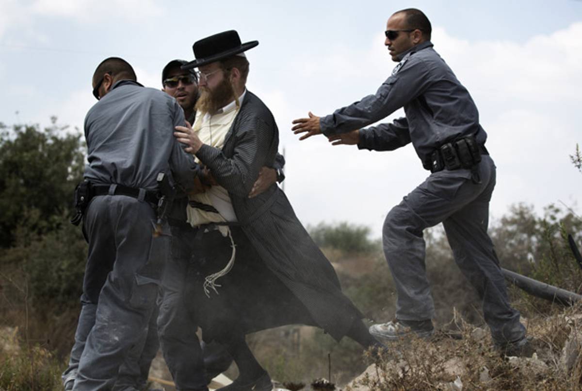An Ultra-Orthodox Jewish man is arrested by Israeli policemen in Ramat Beit Shemesh West of Jerusalem on August 12 2013, after dozens of Haredim protest against desecration of ancient graves were discovered at a new housing construction site.(MENAHEM KAHANA/AFP/Getty Images)