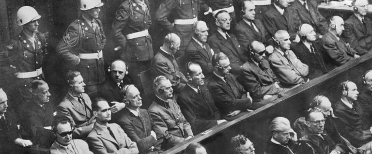21 of the 22 nazi leaders accused of war crimes during the world war II listen to the prosecution 01 October 1946 at the Nuremberg court. From L to R: first row: Goering, Hess, Ribbentrob, Keitel, , Rosenberg, Frank and . Second row: Doenitz, Raeder, Von Schirach, Sauckel, Jodi, Von Papen, Seyss-Inquart, Speer, Von Neurath and Fritzsche. The 22nd defendant, Martin Bormann, was tried in absentia.