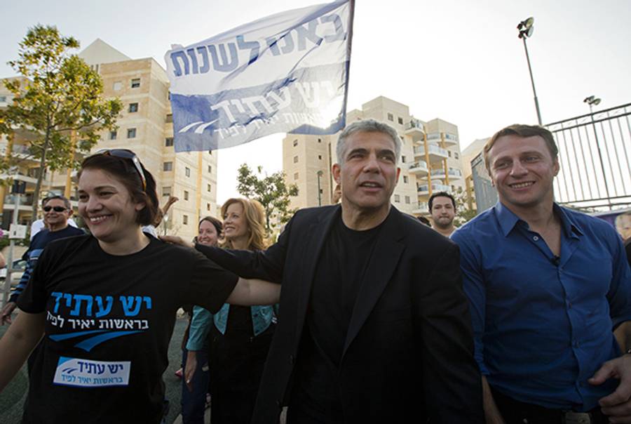 Israeli actor, journalist, and author Yair Lapid (center), leader of the Yesh Atid party, visits a polling station in Netanya on January 22, 2013.(Jack Guez/AFP/Getty Images)