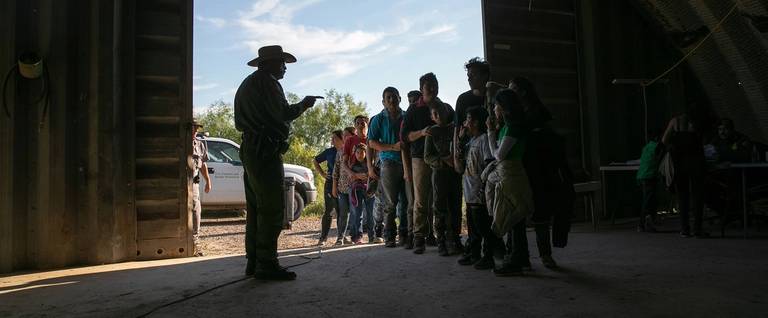 A U.S. Border Patrol agent gives instructions to families, mostly from Central America, who had crossed the Rio Grande from Mexico and presented themselves to agents on Sept. 10, 2019, in Los Ebanos, Texas.