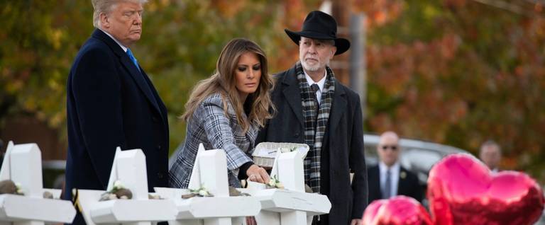 President Donald Trump and First Lady Melania Trump, alongside Rabbi Jeffrey Myers, place stones and flowers on a memorial at the Tree of Life synagogue in Pittsburgh, Oct. 30, 2018.