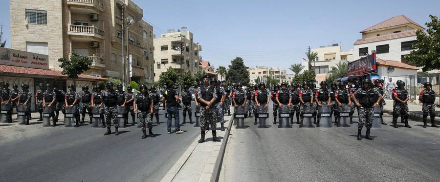Jordanian security forces stand on guard before protesters during a demonstration near the Israeli embassy in the capital Amman on July 28, 2017.