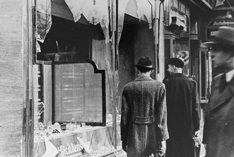 Germans pass by the broken shop window of a Jewish-owned business that was destroyed during Kristallnacht.(USHMM, courtesy of National Archives and Records Administration, College Park)