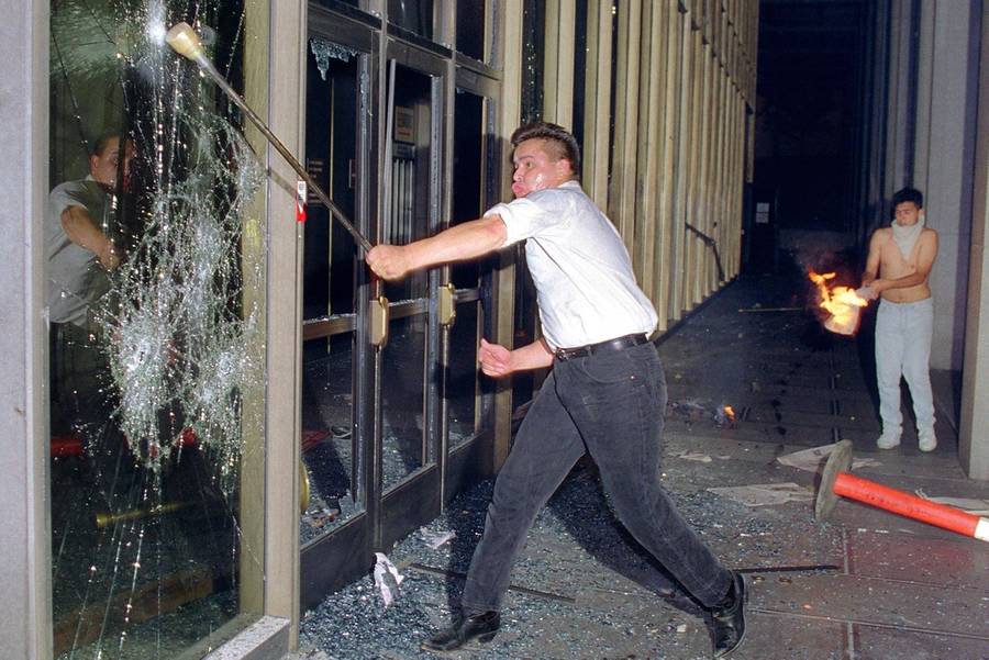A rioter breaks a glass door of the Criminal Courts building, downtown Los Angeles, 29 April 1992, after a jury acquitted four police officers accused of beating a black youth, Rodney King, in 1991. Riots broke out throughout Los Angeles hours after the verdict was announced.