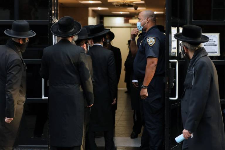 People congregate outside of the Congregation Yetev Lev D'Satmar synagogue on Oct. 19, 2020, in Williamsburg, Brooklyn.