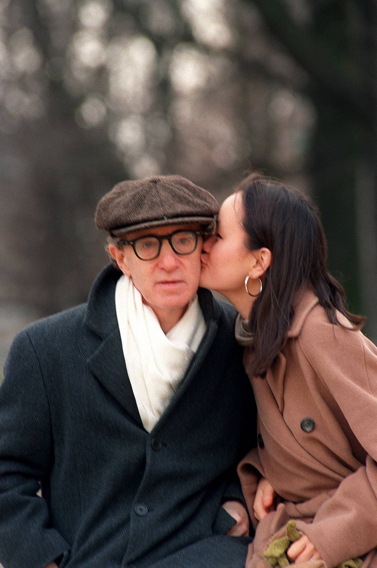 Soon-Yi Previn, wife of American actor and director Woody Allen (L), kisses her husband, 26 December 1997 in the Tuileries Gardens in Paris. (Photo credit Jack Guez/AFP/Getty Images)