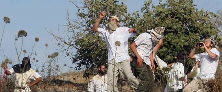 Israeli settlers from the Jewish settlement of Yitzhar throw stones during clashes with Palestinians from the village of Asira al-Qibiliya, south of the West Bank city of Nablus on May 19, 2012. 