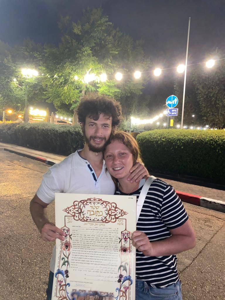 Ori Minzer and Elinor Yossfin with their ketubah. They were in Thailand when they were both summoned for duty. Despite not being engaged, the couple married immediately upon their return to Israel.