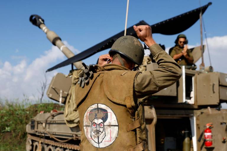 An Israeli soldier wearing a patch on the back of his flak jacket showing Lebanon’s Hezbollah leader Hassan Nasrallah as a target, stands in front of a self-propelled artillery howitzer in Upper Galilee in northern Israel, Jan. 4, 2024