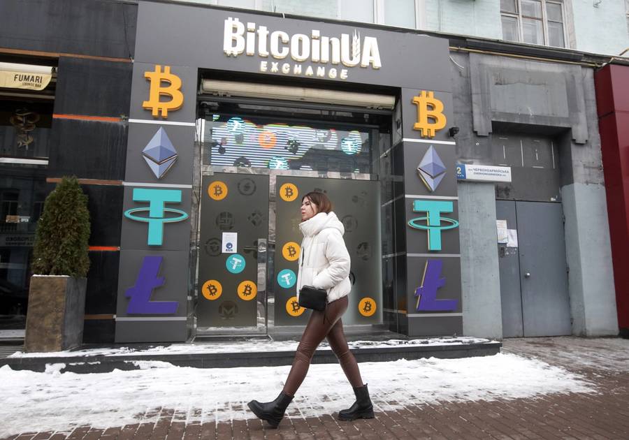 A woman walks past a cryptocurrency exchange point in the center of Kyiv, Ukraine, on Jan. 24, 2022