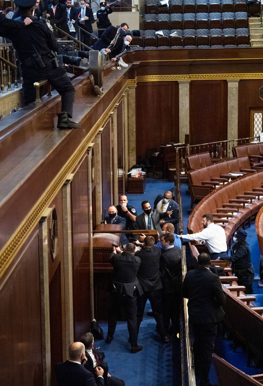 Rep. Troy Nehls, R-Texas, in blue shirt, uses a sign to drive back rioters trying to break into the House chamber to disrupt the joint session of Congress during certification of the Electoral College vote, Jan. 6, 2021