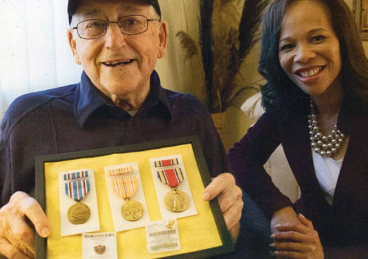 Louis Brown (pictured with Lisa Blunt Rochester) holds WWII medals he received in 2018. (Photo courtesy the author)