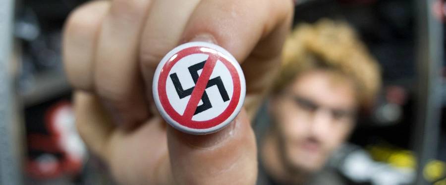 A German man holding an anti-Nazi button.