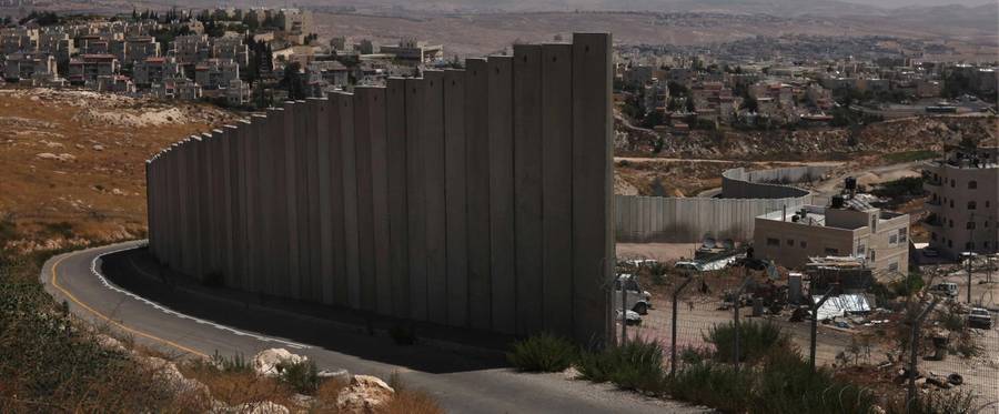 Israel's controversial West Bank barrier weaves its way between the Palestinian refugee camp of Shuafat (front right) and the Jewish neighbourhood of Pisgat Zeev.