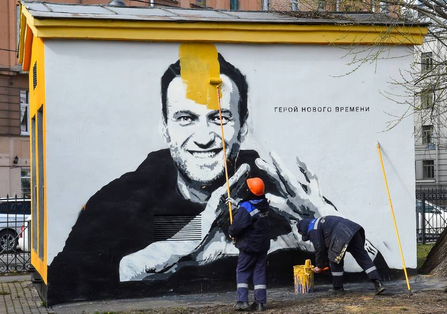 A worker paints over graffiti of jailed Kremlin critic Alexei Navalny in Saint Petersburg, on April 28, 2021. The inscription reads: ‘The hero of the new times.’