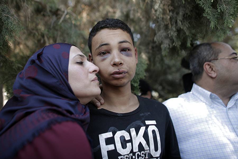 Tariq Abu Khder, a Palestinian-US teenager who was allegedly beaten during police custody, is hugged by his mother following a hearing at Jerusalem Magistrates Court on July 6, 2014. (AHMAD GHARABLI/AFP/Getty Images)