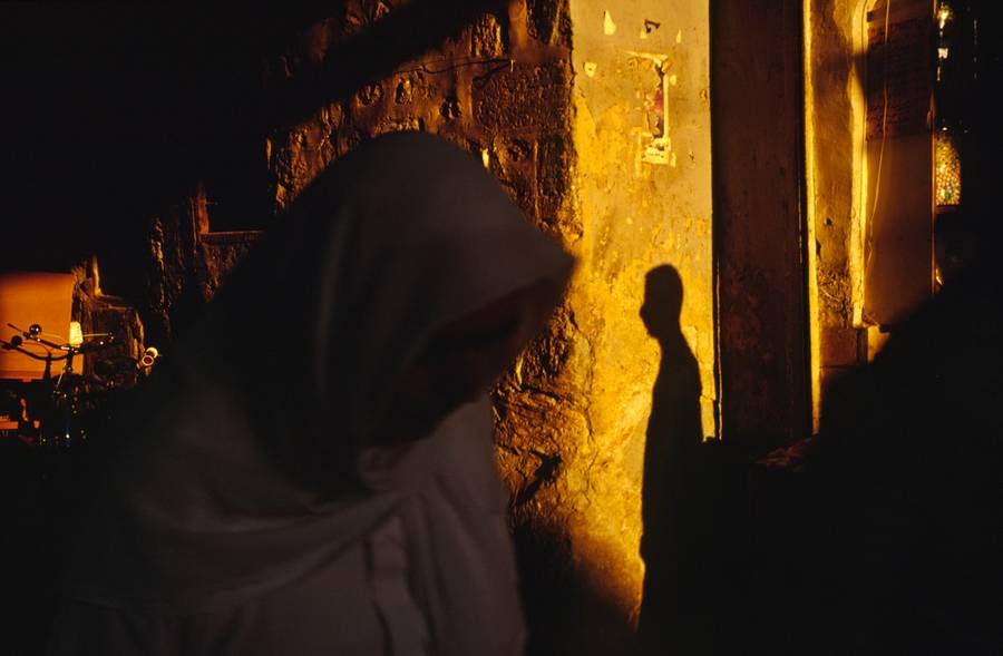 A woman walks through the dark streets of the Souk in Aleppo. 