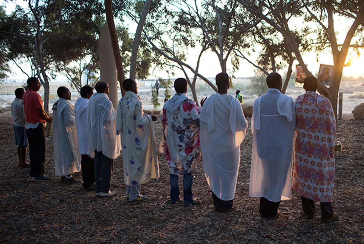 African asylum seekers, who entered Israel illegally in the past years, hold a prayer after they spent the night in an outdoor camp near Nitzana border crossing with Egypt in the Negev Desert on June 28, 2014. (MENAHEM KAHANA/AFP/Getty Images)