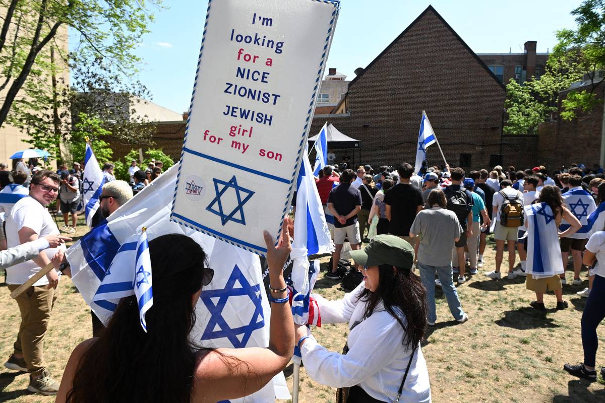 A woman attending a George Washington University rally against campus antisemitism holds a placard in a park in downtown Washington, D.C., on May 2, 2024