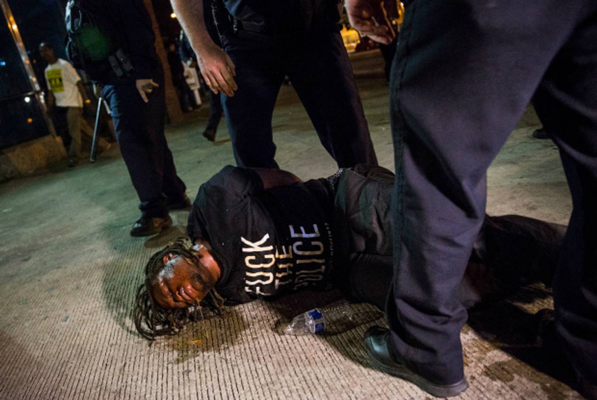  A man is detained after being pepper sprayed in the face by police on May 2, 2015, Baltimore, Maryland. (Andrew Burton/Getty Images)