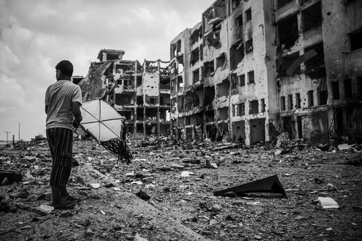 Palestinian child holding a kite in front of al-Nahda towers, Beit Hanoun, Gaza Strip, Aug. 4, 2014. The residents of Beit Hanoun, on the northeastern edge of the Gaza Strip, were evacuated during the Israeli airstrikes. Al-Nahda towers, which included 90 residential flats, were destroyed during the invasion.