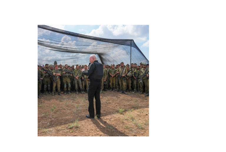 Yoav Gallant speaks with Israeli soldiers in a staging area near the border with the Gaza Strip in southern Israel, Thursday, Oct. 19, 2023