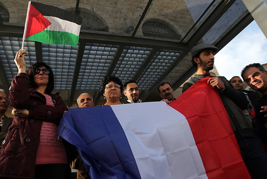 Palestinians hold French and Palestinian flags as they call for France to vote for the recognition of a Palestinian State in Ramallah on December 2, 2014. (ABBAS MOMANI/AFP/Getty Images)