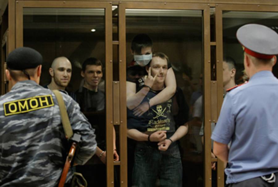 Members of an ultra-nationalist group accused of murdering 27 members of ethnic minorities as they stand in court in Moscow, on July 11, 2011. The group chanted neo-Nazi and anti-Semitic slogans and jeered at the judge on several occasions on July 11 as he started reading out his verdict.(DMITRY KOSTYUKOV/AFP/Getty Images)