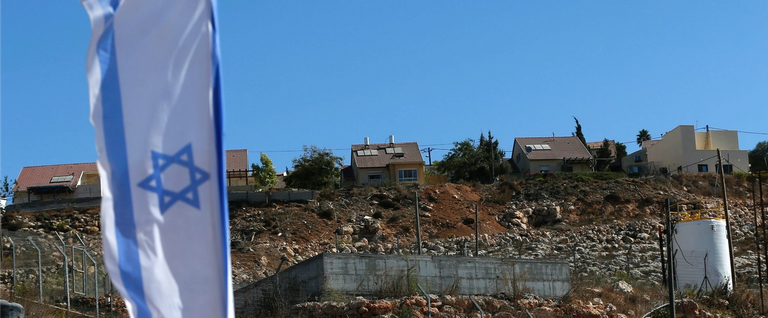 An Israeli national flag flies next to an Israeli building site of new housing units in the Jewish settlement of Shilo in the occupied Palestinian West Bank, October 2, 2016. 
