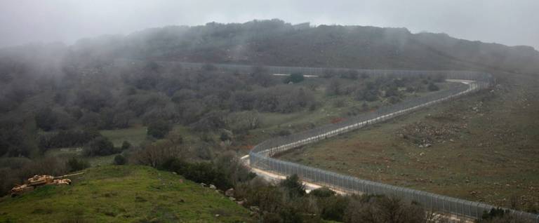 A picture taken on February 21, 2016, from the Israeli-annexed Syrian Golan Heights shows a section of the border fence between the Golan Heights and Syria. 