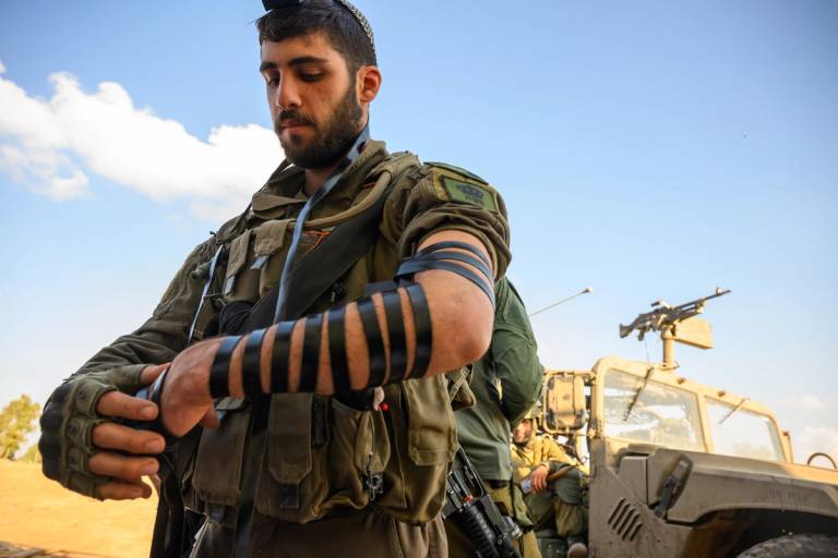 A soldier lays tefillin near the Gaza border in southern Israel on Dec. 6, 2023